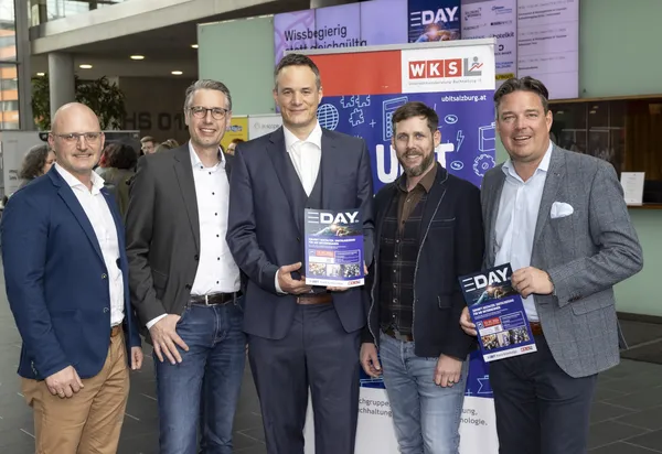2024: Fünf Personen stehen vor einer Infotafel und halten Prospekte beim eDay Salzburg.
