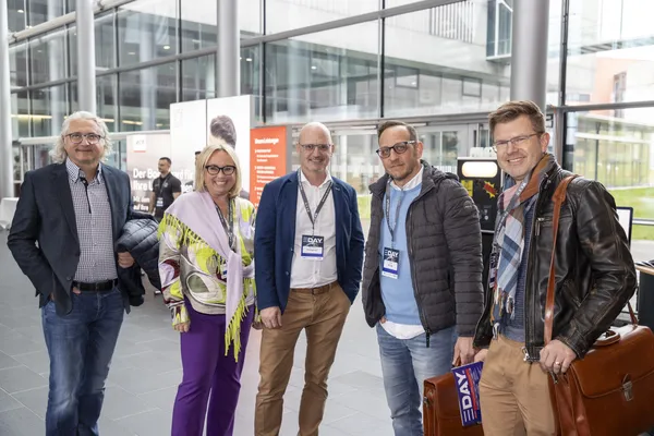 2024: Fünf Personen mit Namensbadges stehen in einer Halle beim eDay Salzburg.
