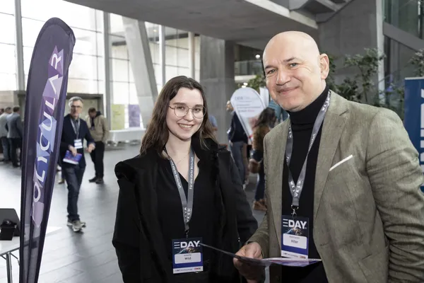 2024: Zwei Personen mit eDay-Badges stehen am Ausstellerstand und lächeln.