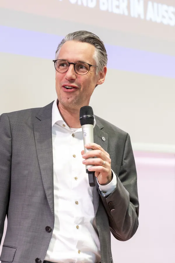 2025: Vortragende Person mit Mikrofon auf der Bühne beim eDay Salzburg.