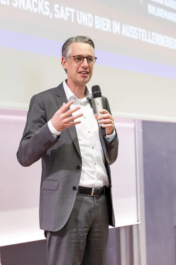 2025: Vortragende Person gestikuliert beim Vortrag auf der Bühne.