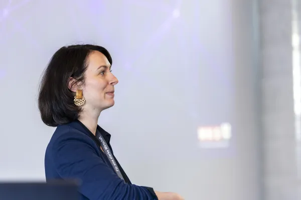 2025: Vortragende Frau im Profil vor Projektionsfläche während Präsentation beim eDay Salzburg.