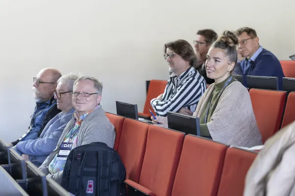 2025: Gelöste Zuhörerinnen und Zuhörer in roten Sitzreihen im Hörsaal beim eDay Salzburg.