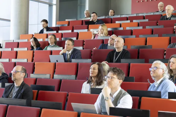 2025: Publikum verteilt auf Hörsaalreihen, mehrere Teilnehmende mit Laptops beim eDay Salzburg.