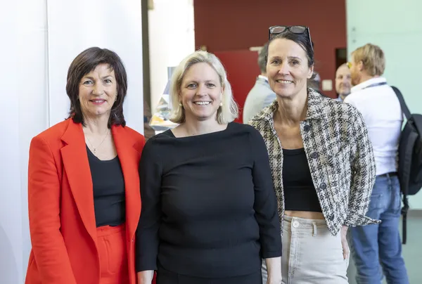 Drei Teilnehmerinnen lächeln in der Konferenzlobby beim eDay Salzburg 2025