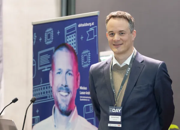Vortragender steht am Rednerpult neben Banner beim eDay Salzburg 2025.