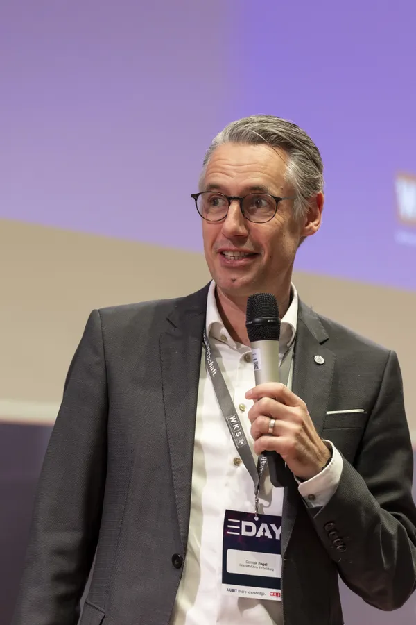Vortragender mit Mikrofon und Badge auf der Bühne beim eDay Salzburg 2026.
