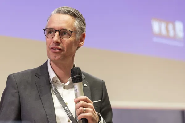 Vortragender mit Mikrofon und Badge auf der Bühne beim eDay Salzburg 2026.