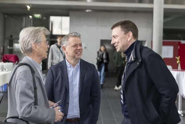 Drei Personen im Gespräch im Foyer beim eDay Salzburg 2026.