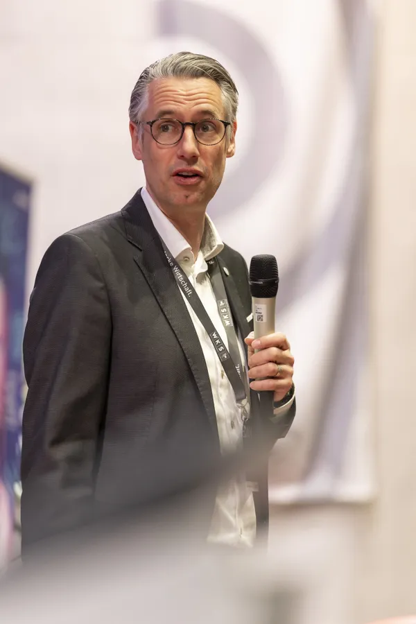 Vortragender mit Mikrofon auf der Bühne beim eDay Salzburg 2026.