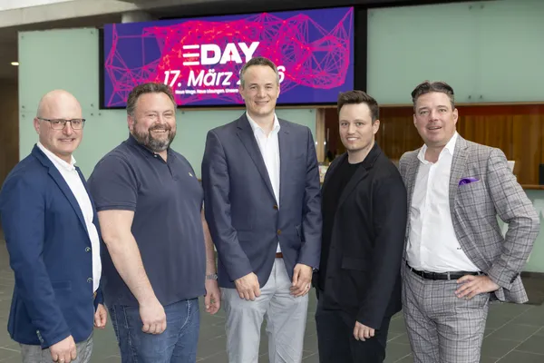 Fünf Personen stehen vor E‑DAY-Banner '17. März 2026' in der Empfangshalle beim eDay Salzburg 2026.