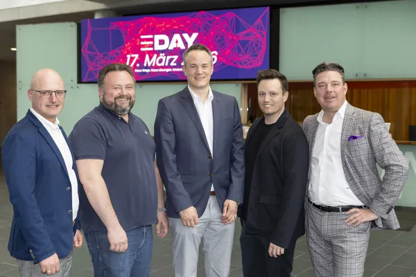 Fünf Personen stehen vor E‑DAY-Banner '17. März 2026' in der Empfangshalle beim eDay Salzburg 2026.