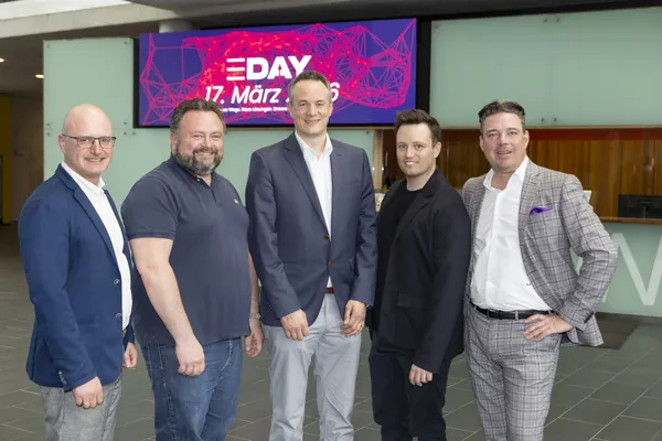 Fünf Personen stehen vor E‑DAY-Banner '17. März 2026' in der Empfangshalle beim eDay Salzburg 2026.