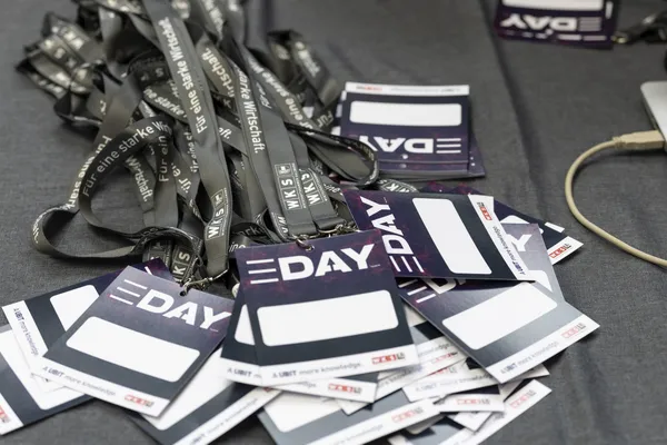 Aufgestapelte Namensschilder und Lanyards mit E‑DAY-Logo beim eDay Salzburg 2026.