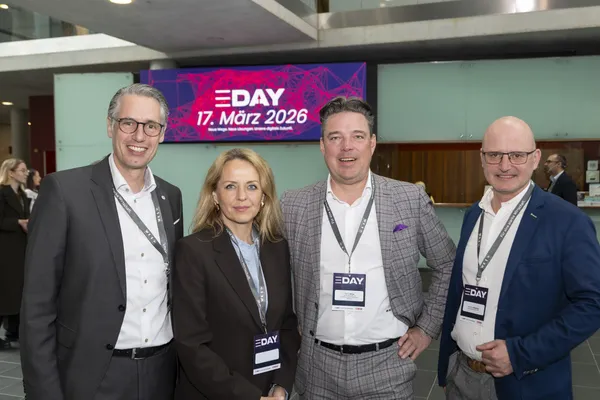 Vier Personen mit Namensschildern posieren vor E‑DAY-Banner '17. März 2026' beim eDay Salzburg 2026.