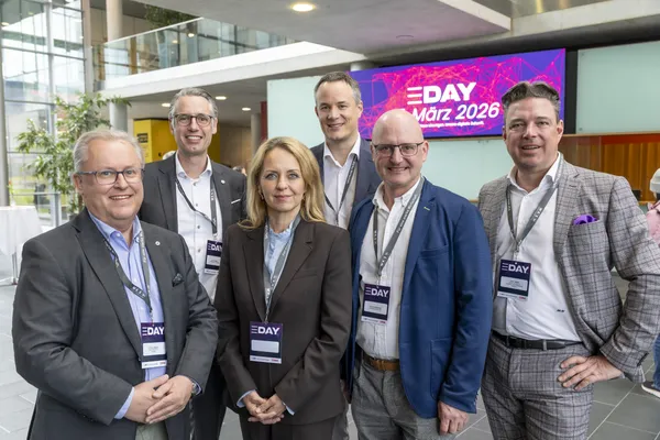 2026: Gruppe von Personen posiert im Foyer vor dem eDay Salzburg-Bildschirm.