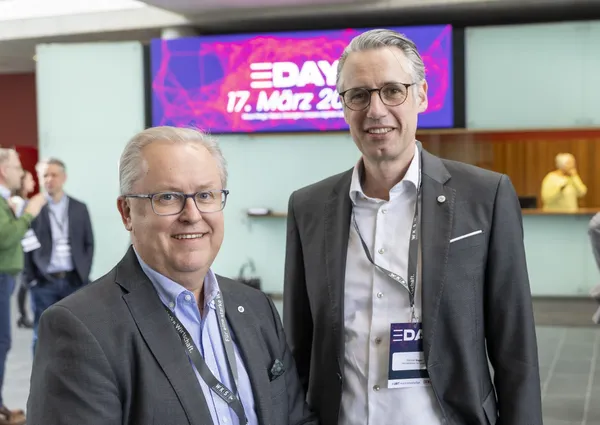 2026: Zwei Personen posieren im Foyer vor dem Bildschirm mit eDay Salzburg-Datum.