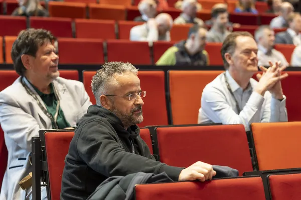 2026: Zuhörender Mann sitzt in der Reihenbestuhlung des Auditoriums beim eDay Salzburg.