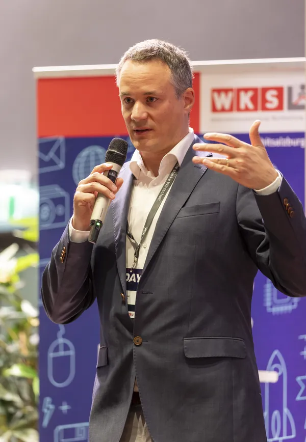 2026: Vortragender gestikuliert mit Mikrofon auf der Bühne beim eDay Salzburg.