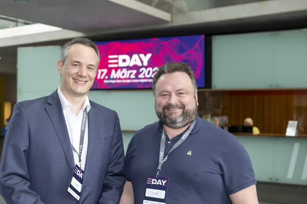 2026: Zwei Männer posieren lächelnd vor dem eDay-Display beim eDay Salzburg.